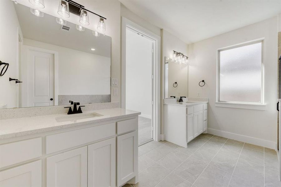 Bathroom with two vanities and a stall shower