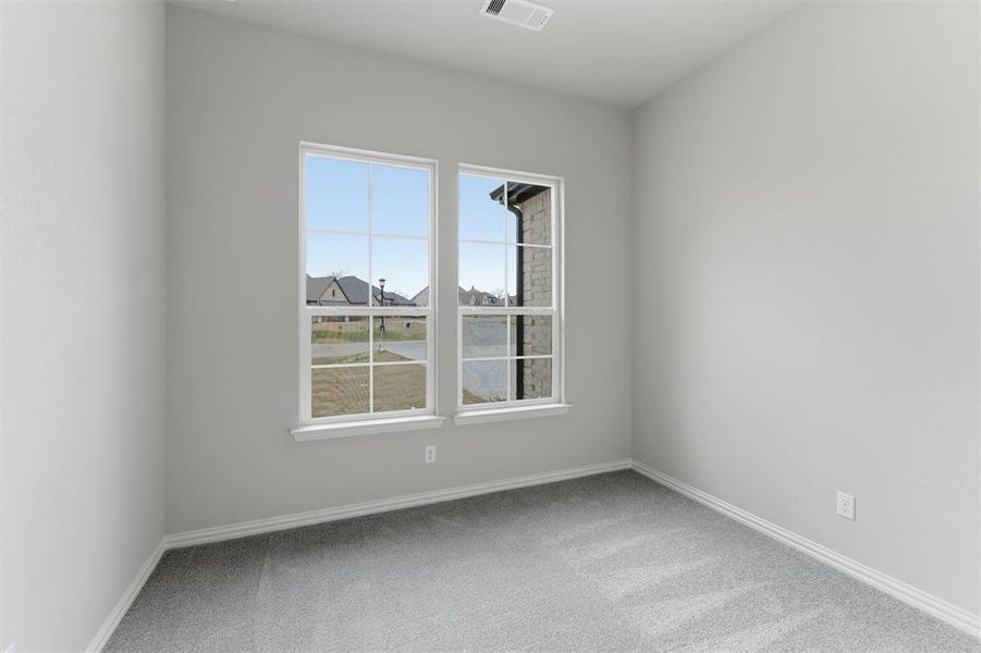 Spare room featuring light carpet and baseboards