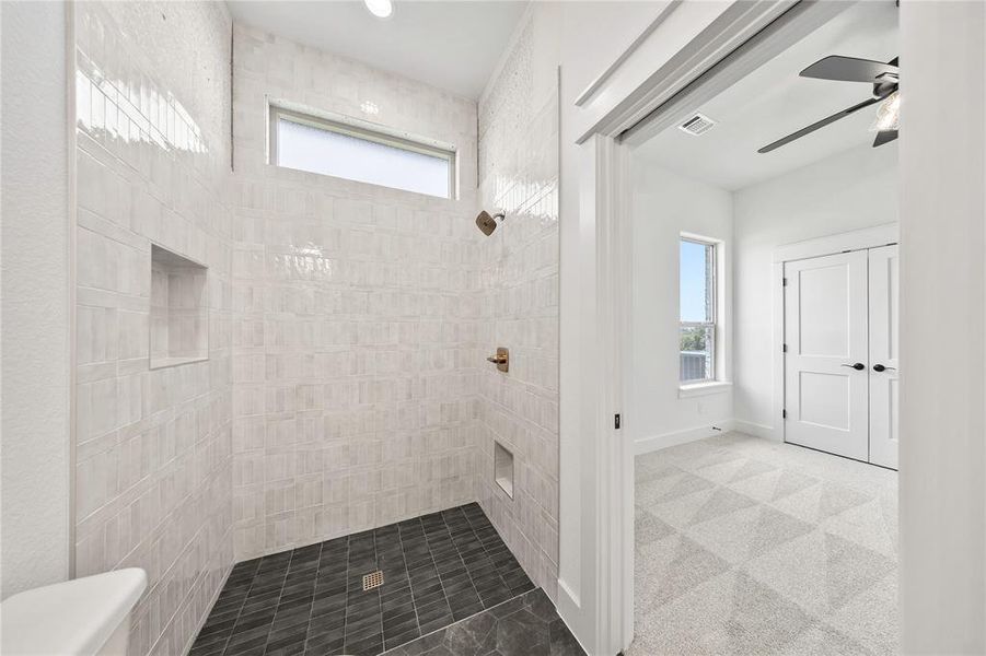 Full bath featuring a tile shower and ceiling fan Full bath featuring a tile shower and ceiling fan