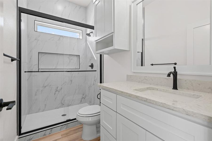 Full bath with vanity and a marble finish shower