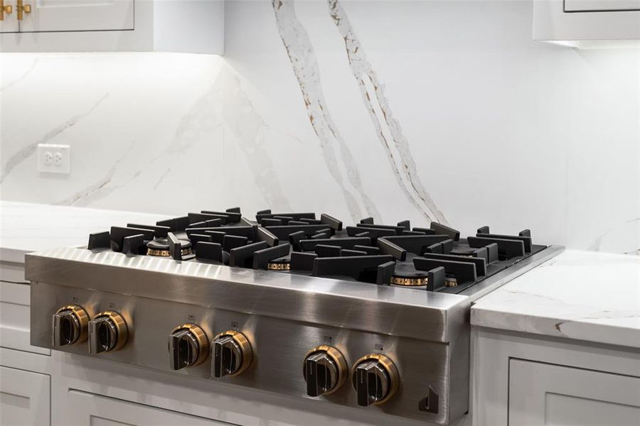 Kitchen view of light stone counters and stainless steel gas stovetop Kitchen view of light stone counters and stainless steel gas stovetop