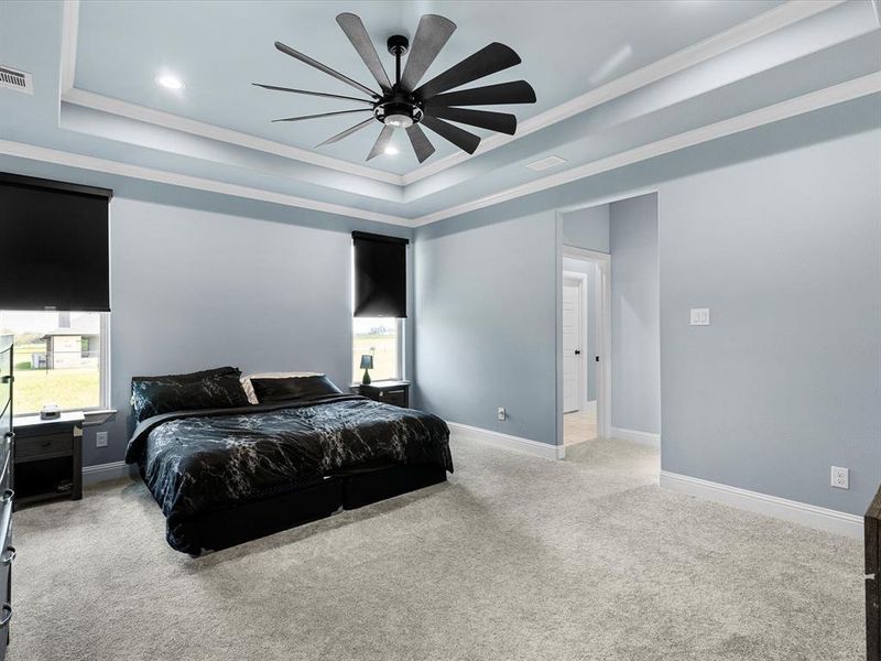 Bedroom with a raised ceiling, crown molding, carpet, a ceiling fan, and recessed lighting Bedroom with a raised ceiling, crown molding, carpet, a ceiling fan, and recessed lighting