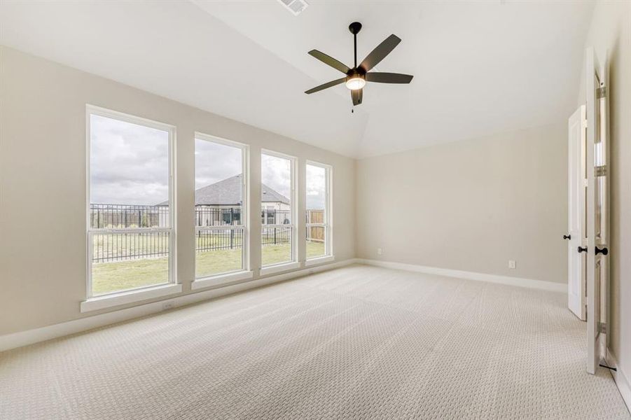 Unfurnished room featuring ceiling fan, light carpet, and lofted ceiling