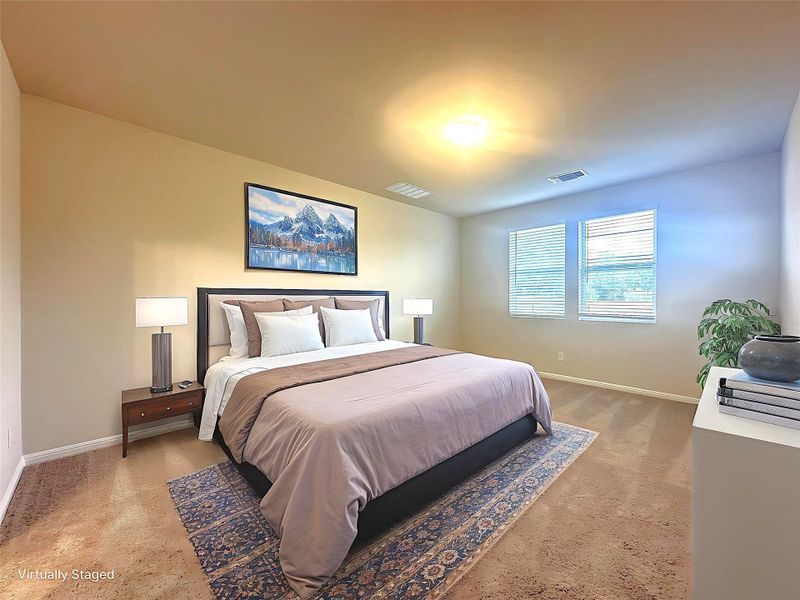 Primary bedroom with baseboards and light colored carpet