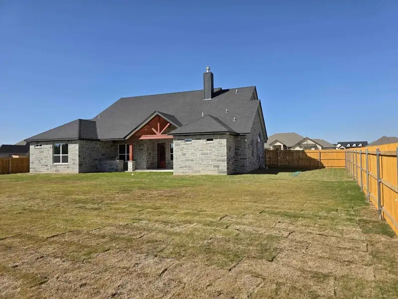Rear view of property featuring a chimney, a patio, a fenced backyard, and brick siding Rear view of property featuring a chimney, a patio, a fenced backyard, and brick siding