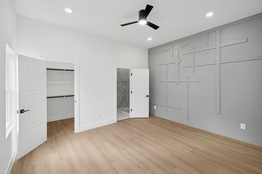 Unfurnished bedroom with light wood-style flooring, a spacious closet, connected bathroom, a ceiling fan, and recessed lighting