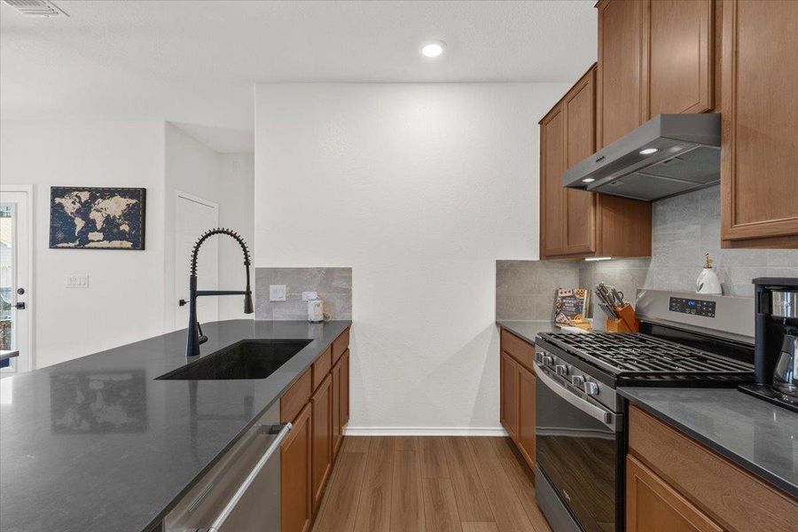 A well-appointed kitchen features dark countertops, sleek cabinetry, and integrated appliances.