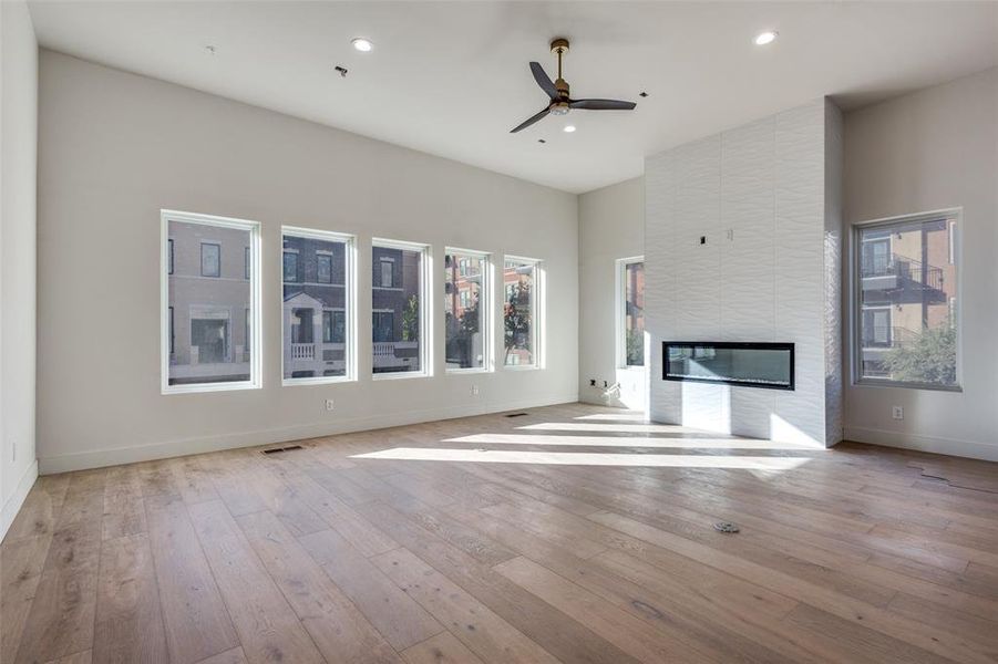 Second floor living room featuring 12 foot ceilings, a large fireplace, and an abundance of windows. This is not the subject property for sale but representation of the finish out of Residence #110.