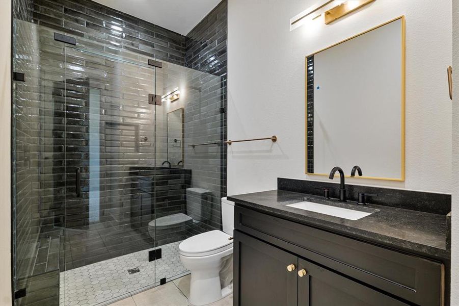 Bathroom with vanity, a shower stall, and tile patterned flooring