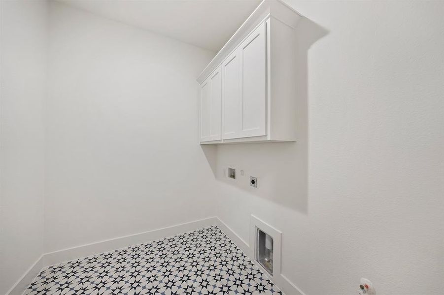 Laundry area featuring cabinet space, hookup for an electric dryer, and washer hookup Laundry area featuring cabinet space, hookup for an electric dryer, and washer hookup