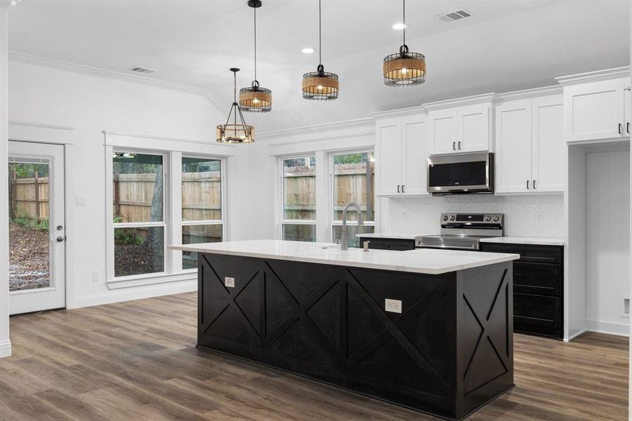 Kitchen with stainless steel appliances, white cabinetry, hanging light fixtures, a kitchen island with sink, and dark wood-type flooring