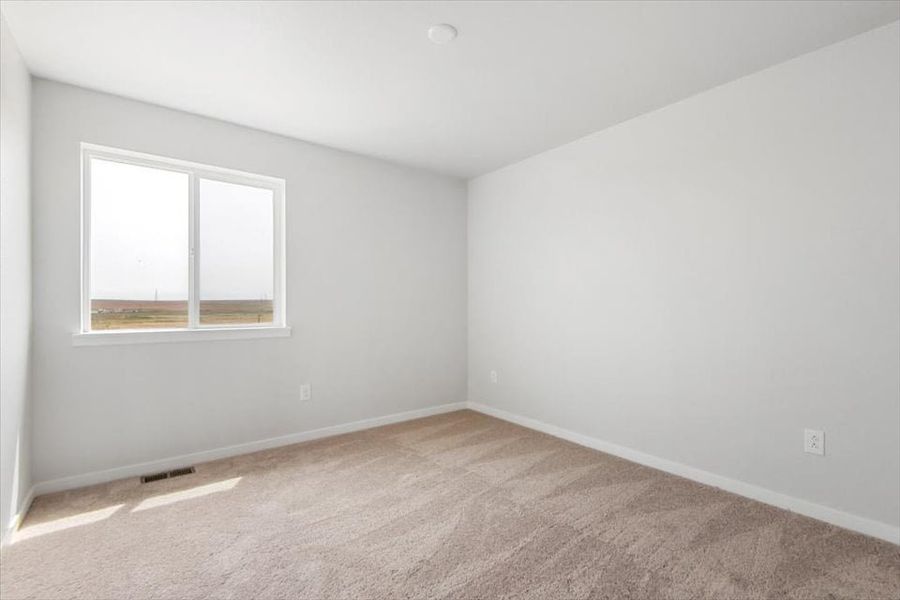 A room with a window and a carpet.