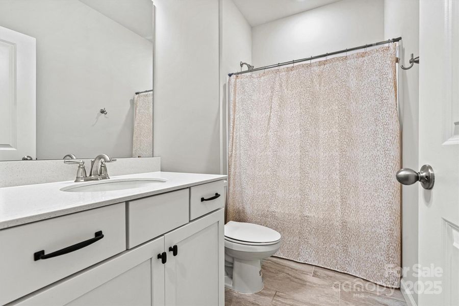 The secondary bedrooms share a spacious, beautifully tiled bathroom featuring a shower/tub combo and a generous vanity with ample drawer storag The secondary bedrooms share a spacious, beautifully tiled bathroom featuring a shower/tub combo and a generous vanity with ample drawer storag