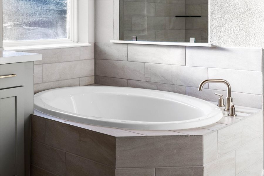 Unwind after a long day in the deep, corner soaking tub, a perfect sanctuary for relaxation. The tub is accented by stylish fixtures.