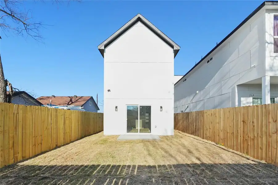 Rear view of house featuring a fenced backyard