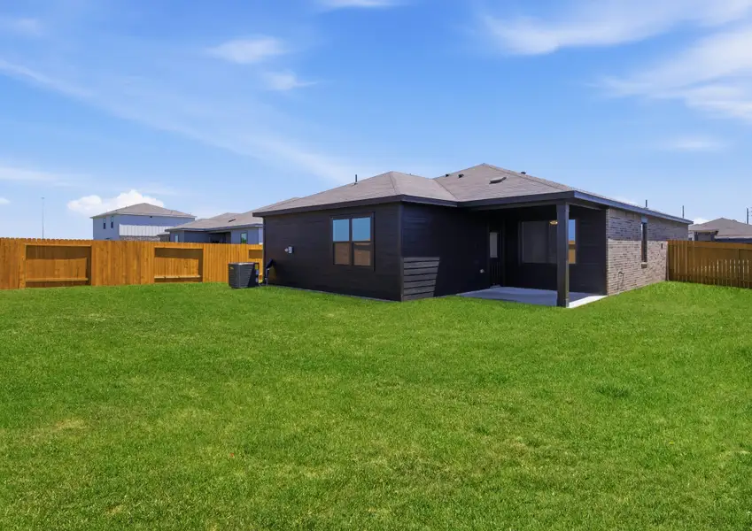 Angled rear exterior of Montgomery floor plan with fenced backyard in Hallimore Ranch