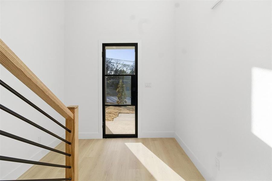 Foyer featuring light wood-style flooring and stairs