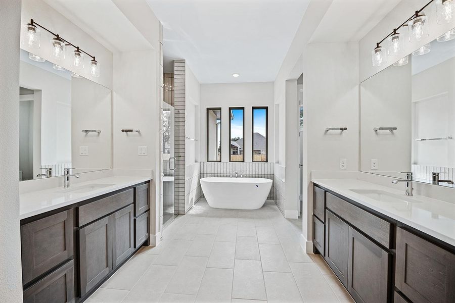 Full bathroom featuring a stall shower, two vanities, a freestanding tub, and tile patterned flooring Full bathroom featuring a stall shower, two vanities, a freestanding tub, and tile patterned flooring