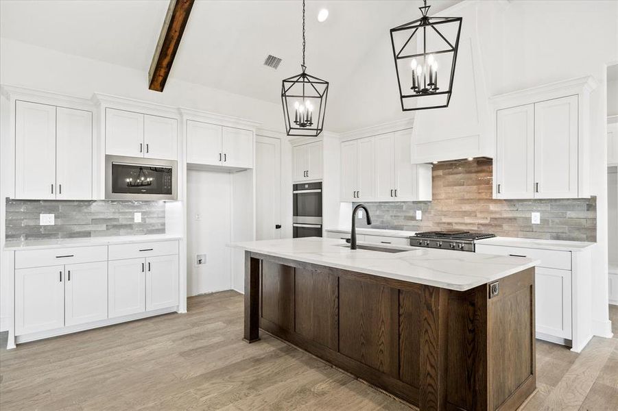 Kitchen featuring backsplash, white cabinetry, sink, and appliances with stainless steel finishes