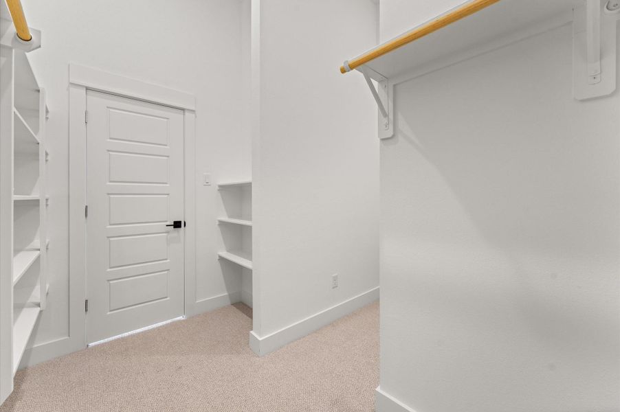 This expansive walk-in closet is a standout feature of the primary bedroom, offering generous space for wardrobe organization and personal storage. Thoughtfully designed shelving and hanging rods, the closet provides a boutique-like experience with room for everything from seasonal clothing to accessories. This expansive walk-in closet is a standout feature of the primary bedroom, offering generous space for wardrobe organization and personal storage. Thoughtfully designed shelving and hanging rods, the closet provides a boutique-like experience with room for everything from seasonal clothing to accessories.