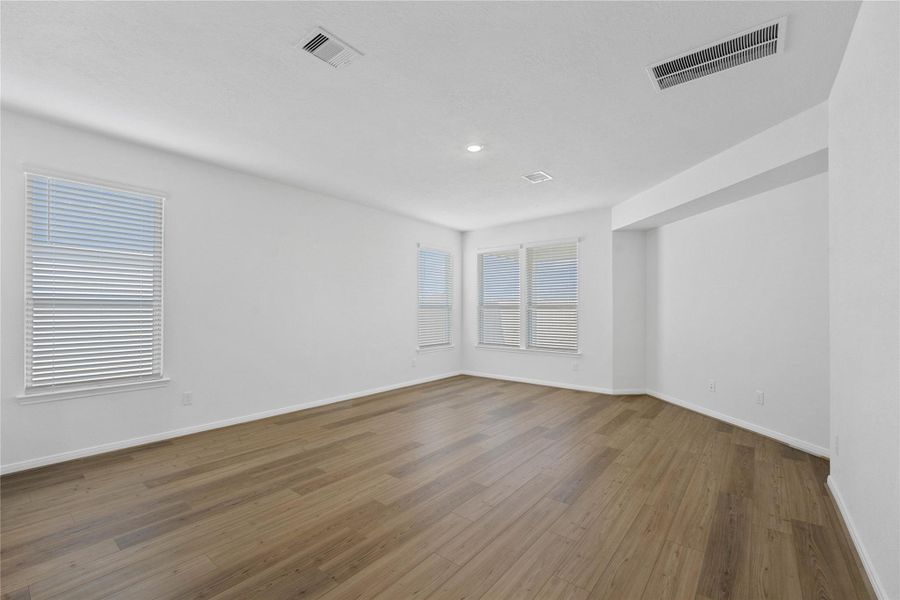 Come and unwind after a long day in this magnificent primary suite! This spacious room features a gorgeous niche in the wall, vinyl plank flooring, neutral paint, high ceilings and large windows with privacy blinds.