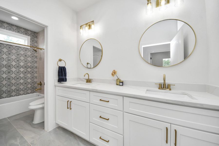 Full bathroom with separate door to shower and toilet offering convenience and double sink vanity. Full bathroom with separate door to shower and toilet offering convenience and double sink vanity.