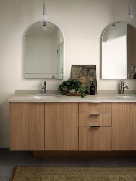 Double vanities with clean-lined wood cabinetry define this modern bath space. Double vanities with clean-lined wood cabinetry define this modern bath space.