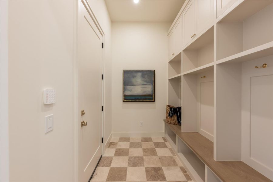 This elegant mudroom is grounded by raw, unfilled travertine flooring in an ivory and noche checkered pattern, adding organic texture beneath custom built-ins with brass hardware. Thoughtfully designed for everyday function, the space combines refined finishes with practical storage in true Elevare form. This elegant mudroom is grounded by raw, unfilled travertine flooring in an ivory and noche checkered pattern, adding organic texture beneath custom built-ins with brass hardware. Thoughtfully designed for everyday function, the space combines refined finishes with practical storage in true Elevare form.