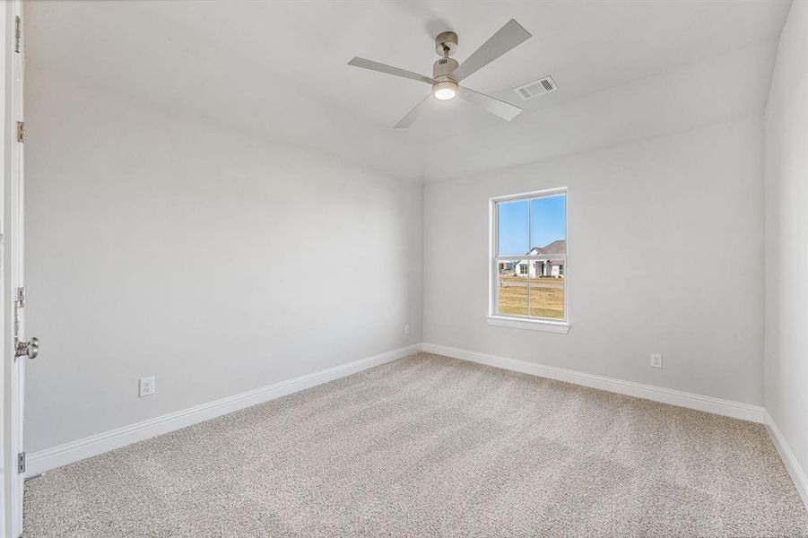 Spare room featuring carpet and a ceiling fan