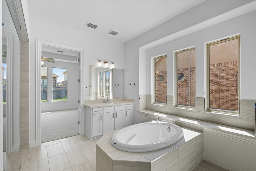 Bathroom featuring vanity, a bath, light tile patterned floors, a ceiling fan, and light colored carpet