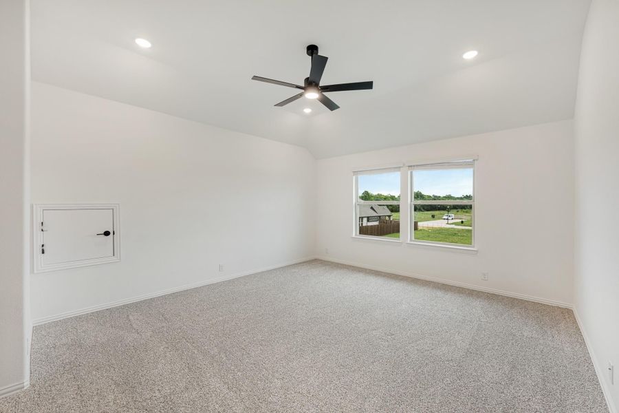Empty bedroom with carpet flooring, black ceiling fan, recessed lighting, and a window with backyard view