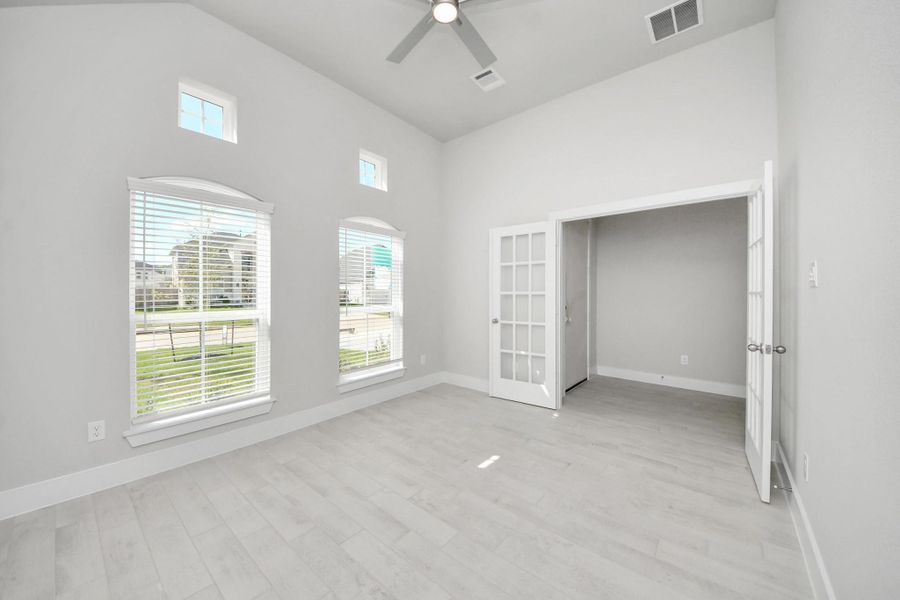 Experience the perfect blend of sophistication and warmth in this home office, boasting elegant wood-look tile flooring and flooded with natural light from expansive windows and French doors. Sample photo of completed home with similar floor plan. Actual colors and selections may vary.