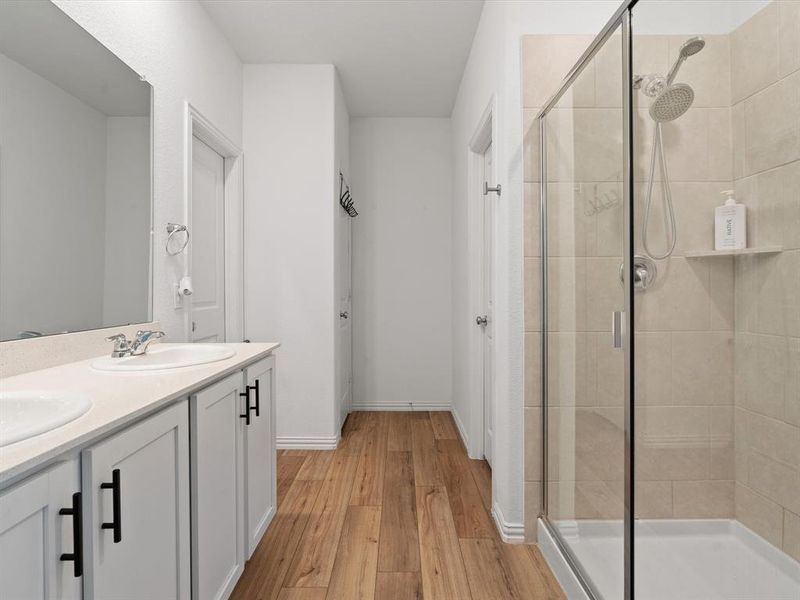 Bathroom featuring vanity, hardwood / wood-style flooring, and walk in shower