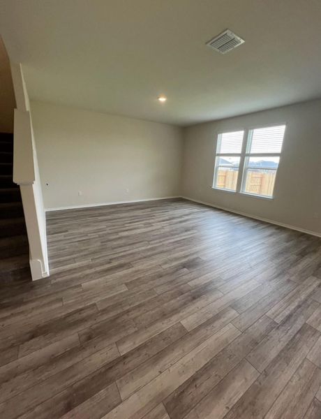 Laminate flooring extends throughout this generous living area, ready for personalization.