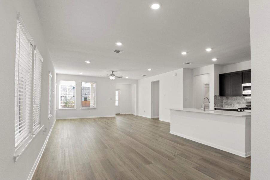 Unfurnished living room with dark wood-style floors, recessed lighting, and ceiling fan