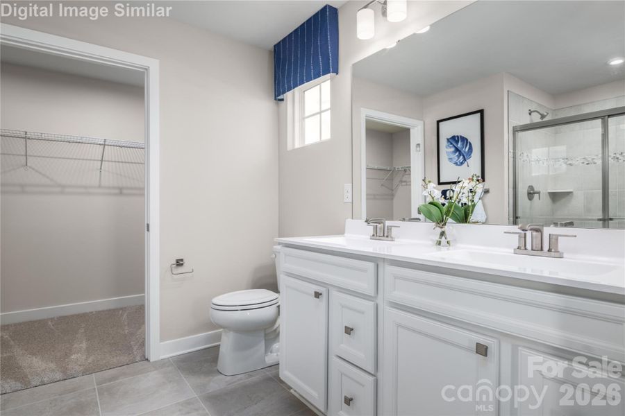 Style meets function: dual vanity flowing into your own walk-in closet.