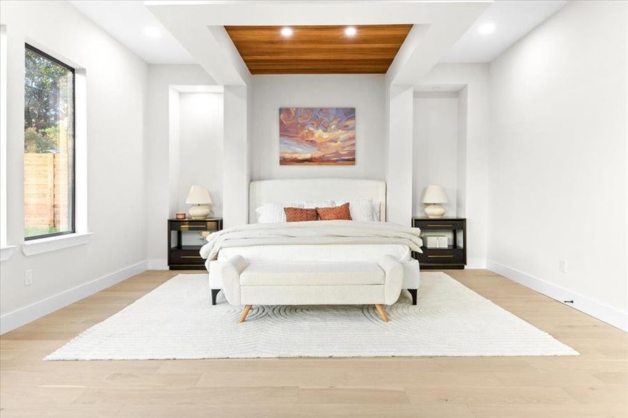 Bedroom with light hardwood / wood-style floors and multiple windows