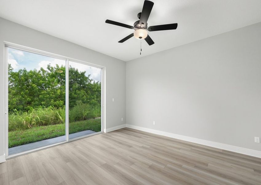 Master bedroom with glass sliding doors that lead to the backyard