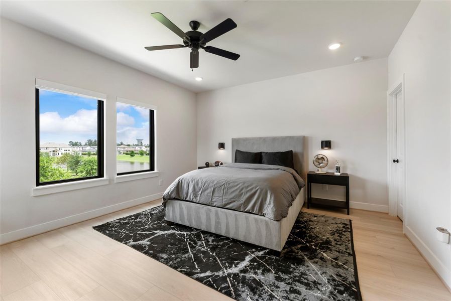 Third upstairs bedroom includes oversized windows with picturesque lake views, recessed lighting, and wide plank flooring. Absolutely no carpet in this home.