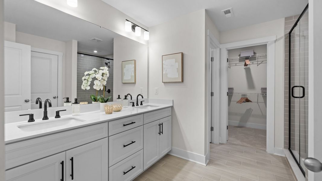Primary bathroom with dual-sink vanity and large walk-in closet in the Jordan Design by DRB Homes in York, SC