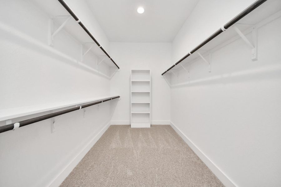 Walk-in closet that epitomizes luxury and practicality. This generously sized space features built-in shelving, offering abundant room for impeccable organization. High ceilings and recessed lighting create a bright and welcoming ambiance.