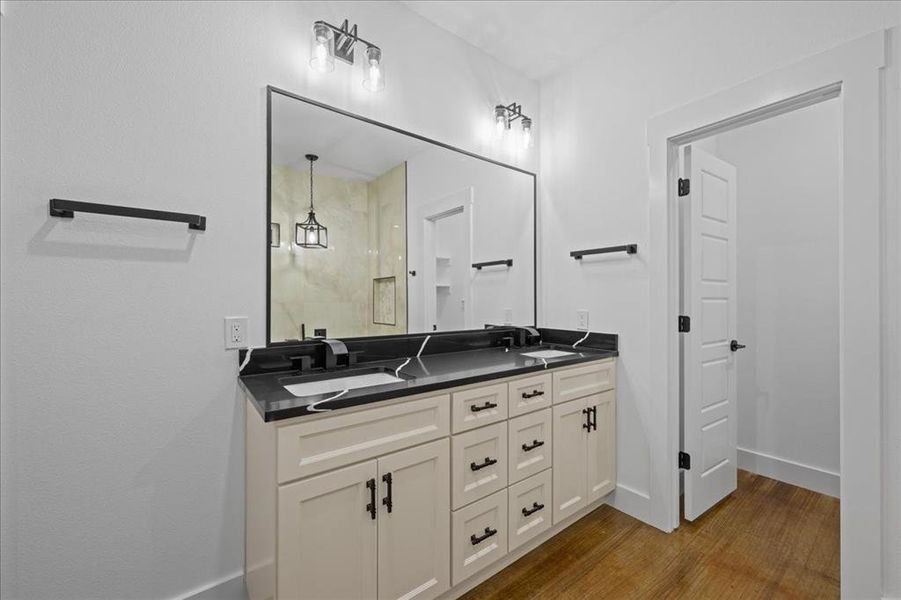 Full bathroom with double vanity and wood-style floors