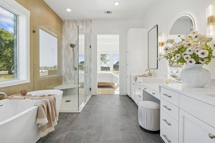 More porcelain tile floors, warm wood-tones, a frameless glass shower, stand-alone tub, and fabulous storage.