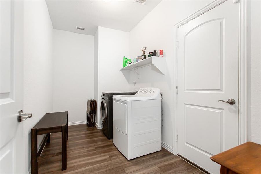 Washroom featuring washing machine and dryer and wood finished floors