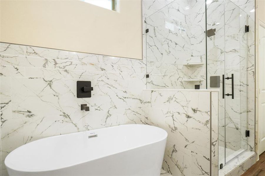 Bathroom featuring plus walk in shower and tile walls