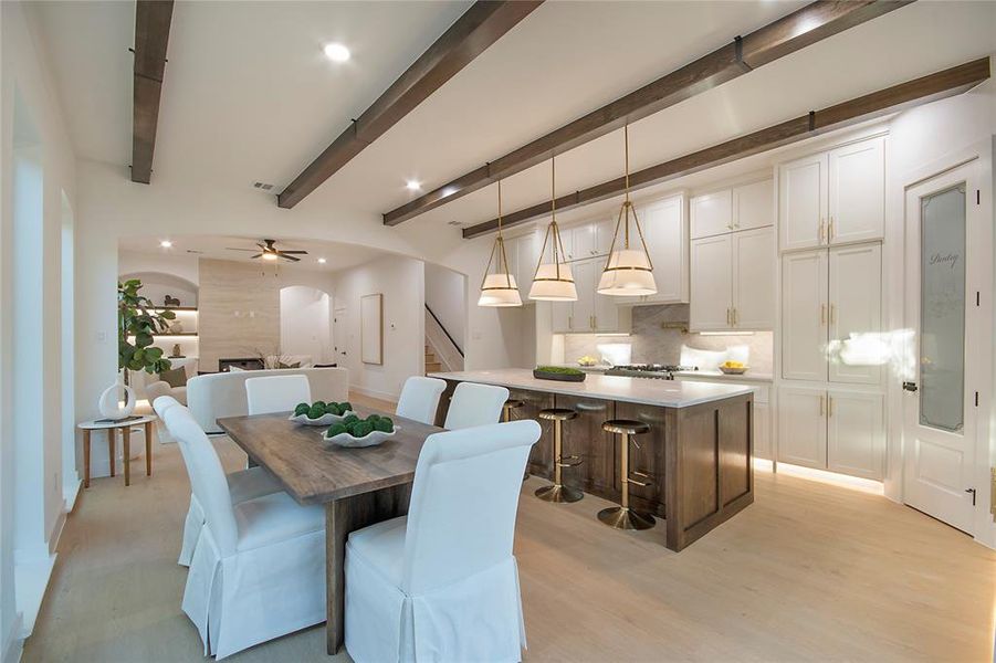 Dining room featuring arched walkways, beam ceiling, stairs, recessed lighting, and light wood-type flooring