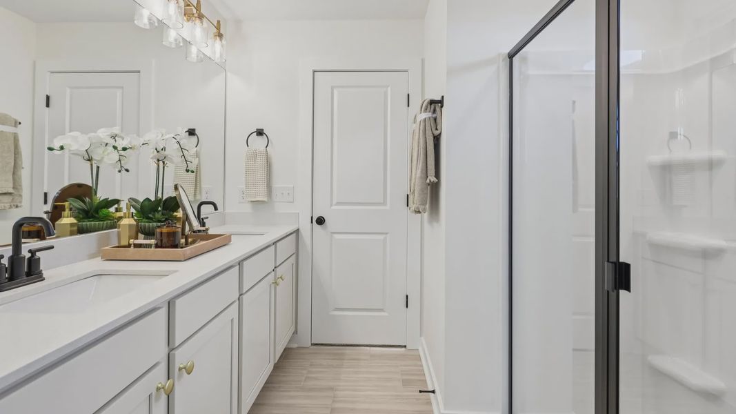 Primary bathroom with dual vanity and glass enclosed shower