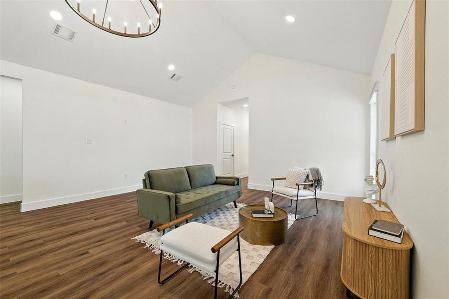 Sitting room with vaulted ceiling, a chandelier, dark wood-style floors, and recessed lighting