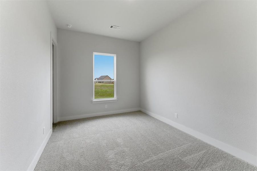 Neutral color palette with textured walls, light-toned carpeting, and a single window with a white frame