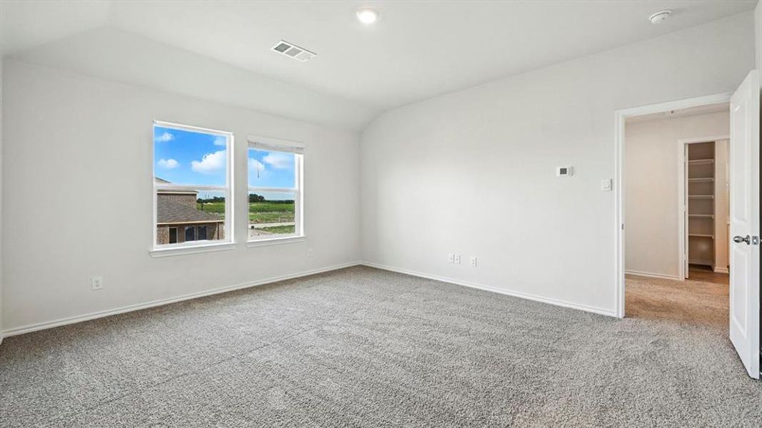 Spacious room with plush gray carpeting, two large windows, white walls, and a vaulted ceiling